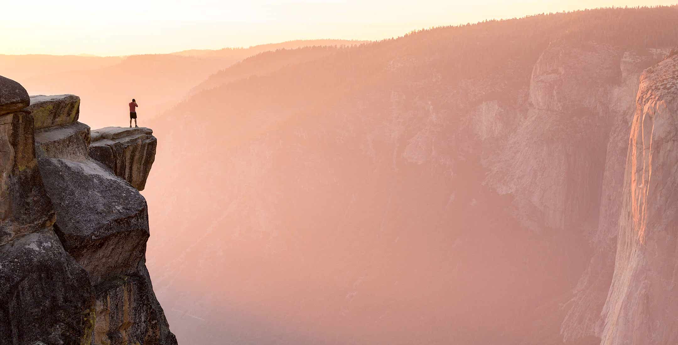 Person enjoys the cliffs at Taft Point at sunset